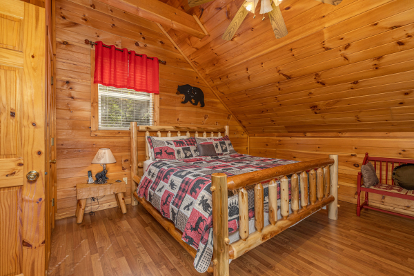 Bedroom with a log bed, bench, and night table at Hidden Joy, a 1 bedroom cabin rental located in Gatlinburg