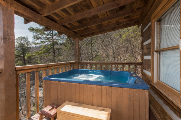 Hot tub on a covered porch at A Postcard View, a 1 bedroom cabin rental located in Pigeon Forge