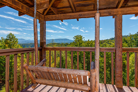 Porch swing on a covered porch at A Postcard View, a 1 bedroom cabin rental located in Pigeon Forge
