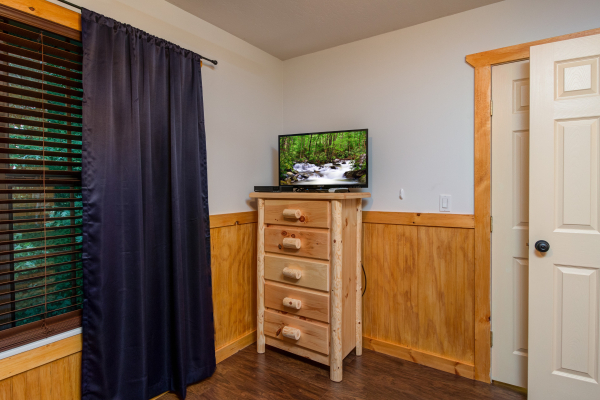 Dresser and TV in a bedroom at The Settlement, a 10 bedroom cabin rental located in Pigeon Forge