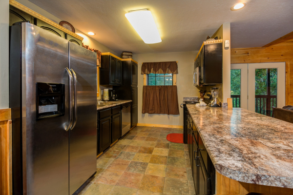 Kitchen with stainless appliances in cabin 1 at The Settlement, a 10 bedroom cabin rental located in Pigeon Forge