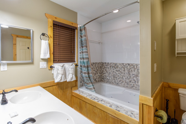 Bathroom with a jacuzzi and shower in cabin 1 at The Settlement, a 10 bedroom cabin rental located in Pigeon Forge