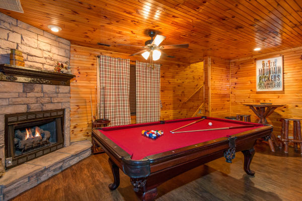 Pool table and fireplace in the cabin 1 game room at The Settlement, a 10 bedroom cabin rental located in Pigeon Forge