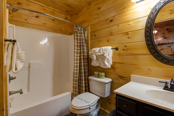 Bathroom with a tub and shower in cabin 1 at The Settlement, a 10 bedroom cabin rental located in Pigeon Forge