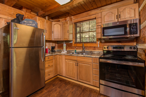 Kitchen with stainless appliances in cabin 3 at The Settlement, a 10 bedroom cabin rental located in Pigeon Forge
