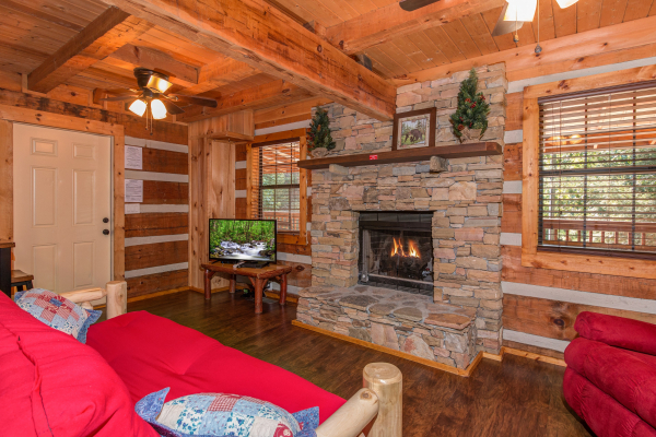 Living room with a fireplace and TV at cabin 3 at The Settlement, a 10 bedroom cabin rental located in Pigeon Forge