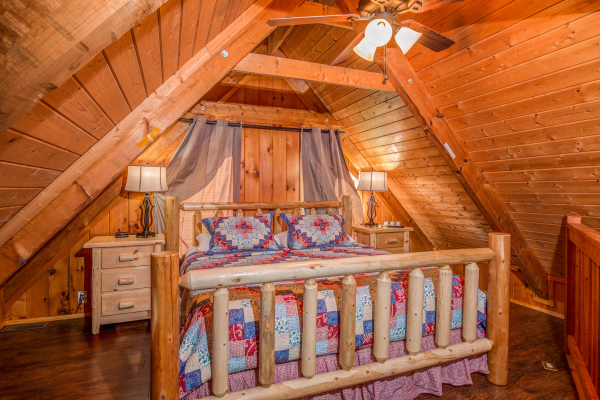 Lofted bedroom with log bed, night stands and lamps in cabin 3 at The Settlement, a 10 bedroom cabin rental located in Pigeon Forge