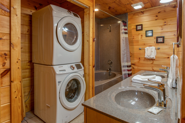 Bathroom with a washer and dryer and a tub with a shower at Hummingbird's Views, a 1 bedroom cabin rental located in Pigeon Forge