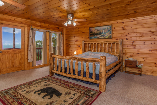 Bedroom with a log bed and deck access at Hummingbird's Views, a 1 bedroom cabin rental located in Pigeon Forge