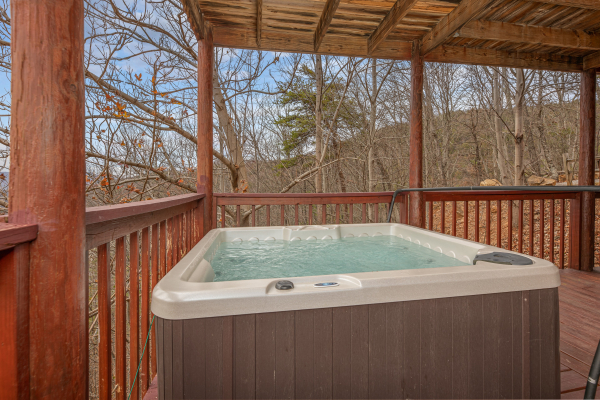 Hot tub on a covered deck at Hummingbird's Views, a 1 bedroom cabin rental located in Pigeon Forge