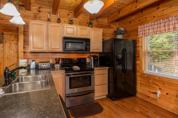 Kitchen with black and stainless appliances at Hummingbird's Views, a 1 bedroom cabin rental located in Pigeon Forge