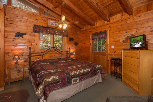 Bedroom with night stands, lamps, dresser, and TV at Hawk's Nest, a 1 bedroom cabin rental located in Pigeon Forge