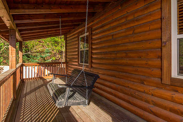 Swing on a covered porch at Rustic Romance, a 2 bedroom cabin rental located in Pigeon Forge