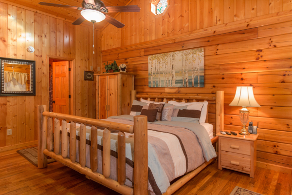 Bedroom with log bed, night stand, and lamp at A Beary Cozy Escape, a 1 bedroom cabin rental located in Pigeon Forge
