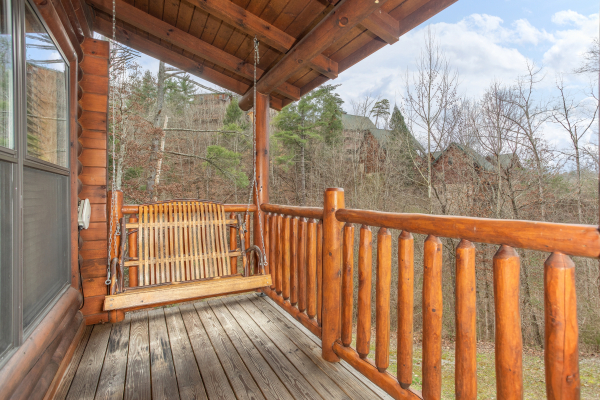 Porch swing on a covered deck at Let the Good Times Roll, a 2 bedroom cabin rental located in Pigeon Forge