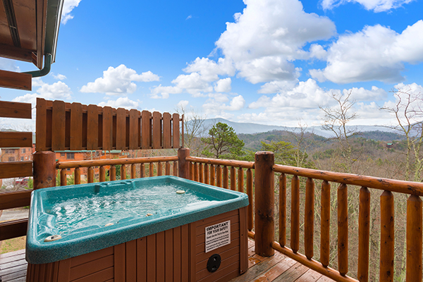 Hot tub with privacy fence and mountain views at Grand Timber Lodge, a 5-bedroom cabin rental located in Pigeon Forge