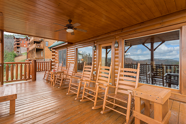 Rocking chairs on a covered deck overlooking the winter views at Grand Timber Lodge, a 5-bedroom cabin rental located in Pigeon Forge