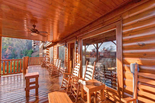 Rocking chairs on a covered deck overlooking the Smokies at Grand Timber Lodge, a 5-bedroom cabin rental located in Pigeon Forge