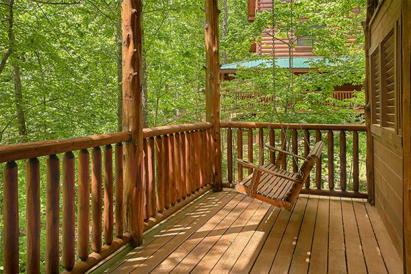 Porch swing on the deck at Bearfoot Paradise, a 3-bedroom cabin rental located in Pigeon Forge
