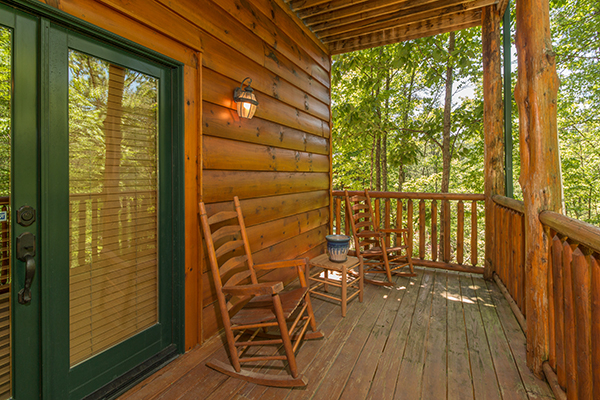 Deck with two rocking chairs and a small table at Bearfoot Paradise, a 3-bedroom cabin rental located in Pigeon Forge