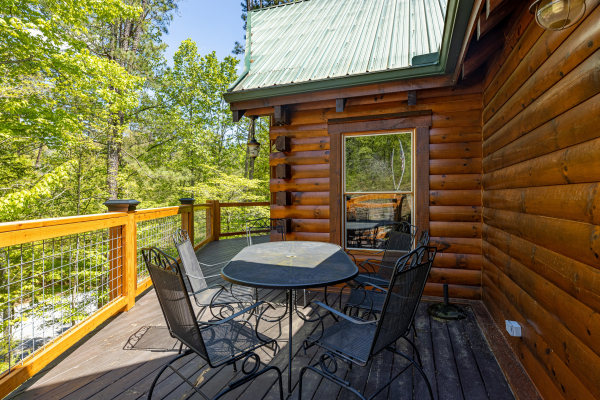 Dining table on the deck at Smokies Paradise Lodge, a 5 bedroom cabin rental located in Pigeon Forge