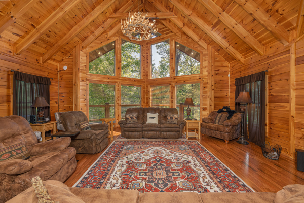 Living room with sofa and large chairs at Smokies Paradise Lodge, a 5 bedroom cabin rental located in Pigeon Forge