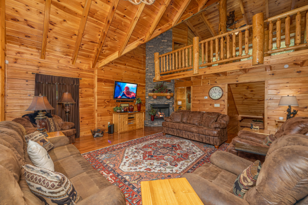 Fireplace and TV in the living room at Smokies Paradise Lodge, a 5 bedroom cabin rental located in Pigeon Forge