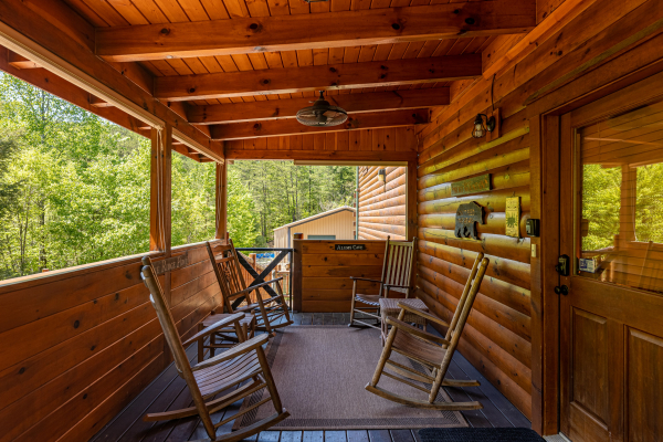 Rocking chairs on a covered porch at Smokies Paradise Lodge, a 5 bedroom cabin rental located in Pigeon Forge