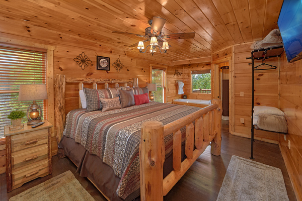 Bedroom with a king-sized log bed at Makin' Honey, a 1 bedroom cabin rental located in Pigeon Forge