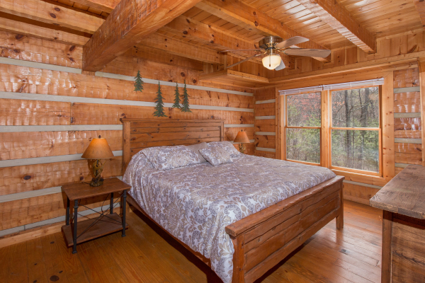 Bedroom with a bed, night stands, and lamps at Ella-Vation, a 3 bedroom cabin rental located in Gatlinburg