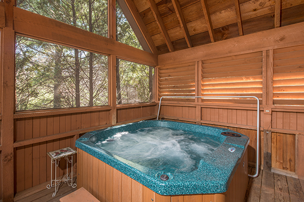 Hot tub on the screened in porch at Golden Memories, a 1-bedroom cabin rental located in Pigeon Forge