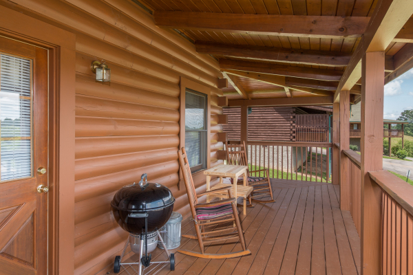 Covered front porch with rocking chairs and a grill at Momma Bear, a 2 bedroom cabin rental located in Pigeon Forge