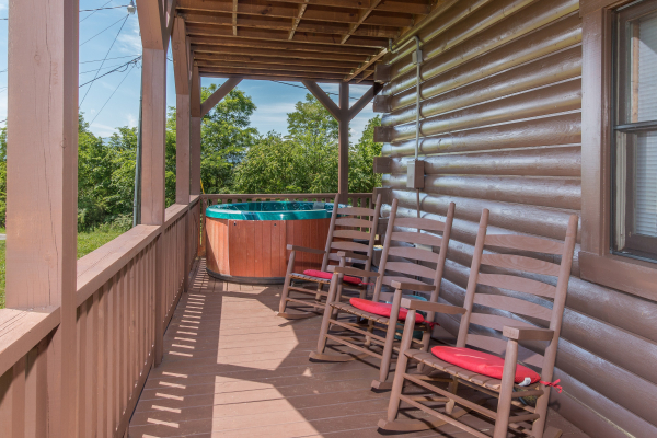 Hot tub and rocking chairs on a covered deck at Moose Lodge, a 4 bedroom cabin rental located in Sevierville
