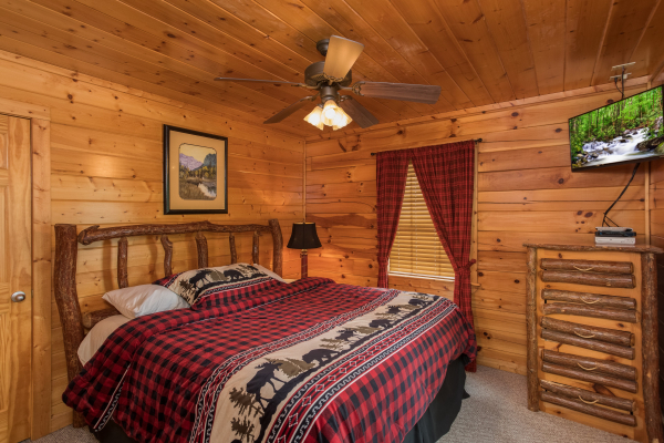 Bedroom with a dresser and TV at Kick Back & Relax! A 4 bedroom cabin rental located in Pigeon Forge