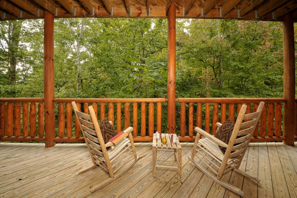 Two rocking chairs overlooking the woods at Family Ties Lodge, a 4-bedroom cabin rental located in Pigeon Forge