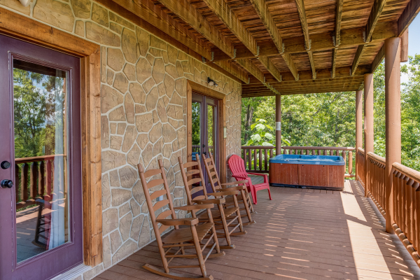 Deck with rocking chairs and a hot tub at Endless View, a 4 bedroom cabin rental located in Pigeon Forge