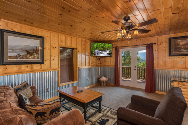 TV and deck access in the lower living room at Endless View, a 4 bedroom cabin rental located in Pigeon Forge