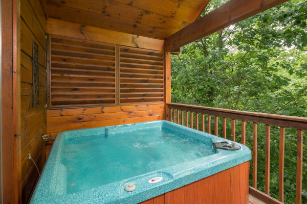 Hot tub on a covered deck at Kelly's Cabin, a 1 bedroom cabin rental located in Pigeon Forge
