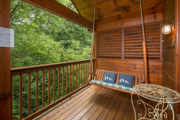 Porch swing on a covered deck at Kelly's Cabin, a 1 bedroom cabin rental located in Pigeon Forge
