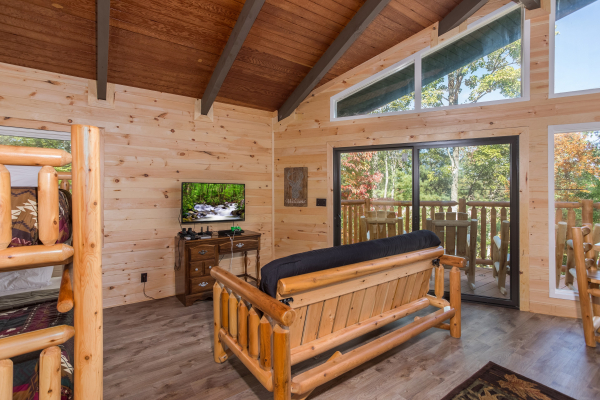 Futon, TV, and deck access in the loft at Forever Country, a 3 bedroom cabin rental located in Pigeon Forge