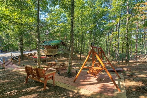 Outdoor space with a bench, picnic table, and log swing at Bearfoot Adventure, a Gatlinburg Cabin rental