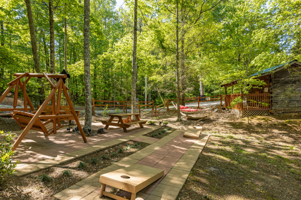 Cornhole, a swing, and a hammock on the patio at Bearfoot Adventure, a 2 bedroom cabin rental located in Gatlinburg