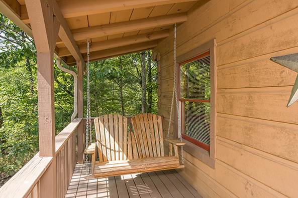 Porch swing on a covered deck at bearfoot adventure a 2 bedroom cabin rental located in gatlinburg