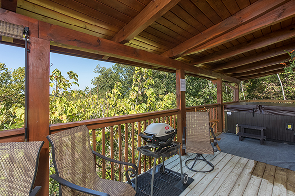 Grill and hot tub on the covered deck at Lake Life, a 4 bedroom cabin rental located in Sevierville