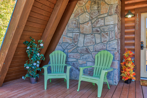 Green adirondack chairs on the deck at Living on Love, a 2 bedroom cabin rental located in Pigeon Forge