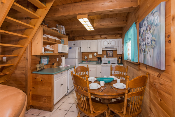 Dining table for four in the kitchen at Living on Love, a 2 bedroom cabin rental located in Pigeon Forge