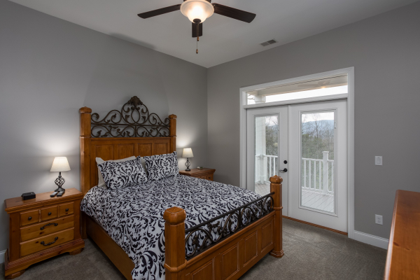 Bedroom with night stands, lamps, and deck access at Summit Glory, a 5 bedroom cabin rental located in Pigeon Forge