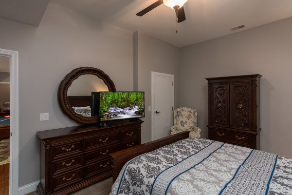 Dresser, TV and armoire in a bedroom at Summit Glory, a 5 bedroom cabin rental located in Pigeon Forge