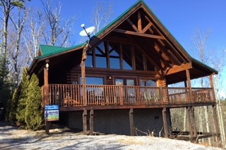 Looking up at the cabin and the wrap around deck at Bootlegger's Bounty, a 1-bedroom cabin rental located in Pigeon Forge