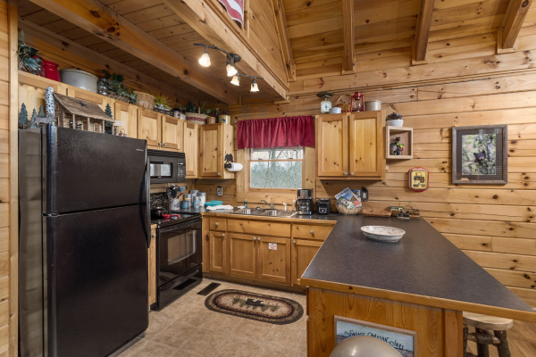 Kitchen with black appliances at Bootlegger's Bounty, a 1-bedroom cabin rental located in Pigeon Forge
